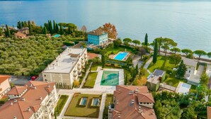 A coastal hotel with multiple buildings, a swimming pool, and a view of the sea.