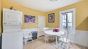 A compact kitchen with a white refrigerator, a washing machine, and a dining area with a round table and white chairs. - 5 Mi to Dtwn Boston! Family-Friendly Medford Apt (Medford)