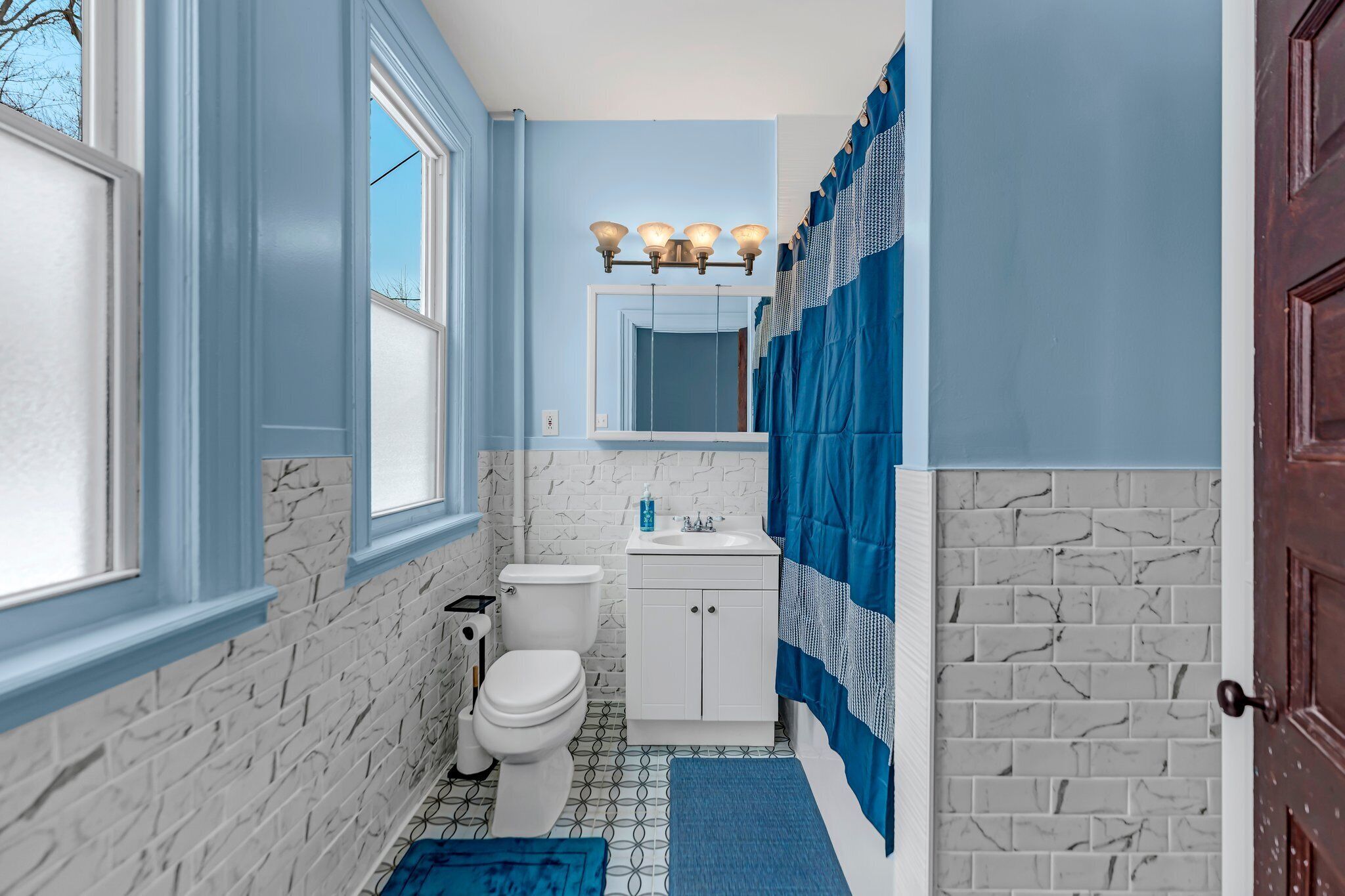 Une salle de bain avec des toilettes, un lavabo et un miroir.
