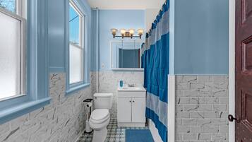Une salle de bain avec des toilettes, un lavabo et un miroir.