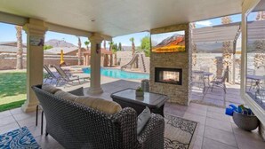 An outdoor patio with wicker furniture, a fireplace, and a pool. - Resort Style Vacation Home (El Paso)