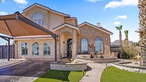 A two-story house with a brick facade, a covered patio, and a well-maintained lawn. - Resort Style Vacation Home (El Paso)