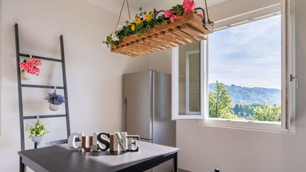 A kitchen with a table labeled 'CUISINE,' a refrigerator, a hanging plant, and a view through a window. - * Villa Maximus - Stunning mountain views (Barga)