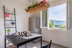 A kitchen with a table labeled 'CUISINE,' a refrigerator, a hanging plant, and a view through a window. - * Villa Maximus - Stunning mountain views (Barga)