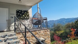 A stone staircase leading to a balcony with a metal railing, a metal birdcage, and a view of mountains. - * Villa Maximus - Stunning mountain views (Barga)