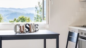A kitchen with a window view of mountains, a table with a 'CUST' sign, and a chair. - * Villa Maximus - Stunning mountain views (Barga)