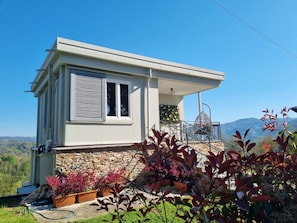 A modern house with a stone foundation, a balcony with a metal railing, and a clear view of the surrounding landscape. - * Villa Maximus - Stunning mountain views (Barga)