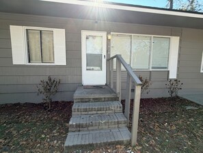 A two-story house with a front door, two windows with shutters, and a concrete staircase leading to the door. - Valdosta relax getaway (Valdosta)
