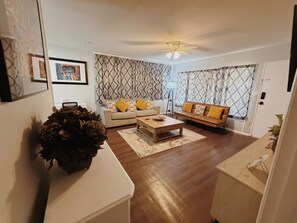A living room with a sofa, coffee table, and decorative plants. - Valdosta relax getaway (Valdosta)