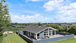 A modern house with a large deck, a swimming pool, and a well-maintained lawn. - Amazing home in Tarm with kitchen (Tarm)