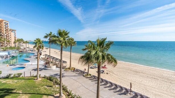 A resort with a pool, beach, and palm trees. - Dang This Place Fancy / Sonoran Sea / Sandy Beach / Beachfront End Unit (Puerto Peñasco)