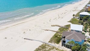 A beachside property with a long pier extending into the ocean, adjacent to a sandy beach and a row of buildings. - SunScape & SeaScape: Beachfront, 2 Kitchens, Elevator, Pool/Spa, Pet-Friendly (Port Saint Joe)