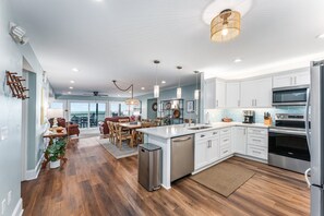 A modern kitchen with white cabinets, stainless steel appliances, and a central island. - SunScape & SeaScape: Beachfront, 2 Kitchens, Elevator, Pool/Spa, Pet-Friendly (Port Saint Joe)