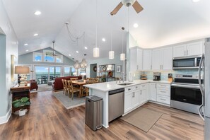 A spacious kitchen with modern appliances, a dining area with a view, and a cozy seating space. - SunScape & SeaScape: Beachfront, 2 Kitchens, Elevator, Pool/Spa, Pet-Friendly (Port Saint Joe)