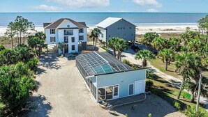A coastal property with a large house, a greenhouse, and a beach view. - SunScape & SeaScape: Beachfront, 2 Kitchens, Elevator, Pool/Spa, Pet-Friendly (Port Saint Joe)