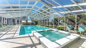 Ein Innenpool mit Glasdach, umgeben von Liegestühlen und einer Terrassenanlage.