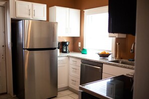 Mikrobølgeovn, ovn, oppvaskmaskin og spisebord