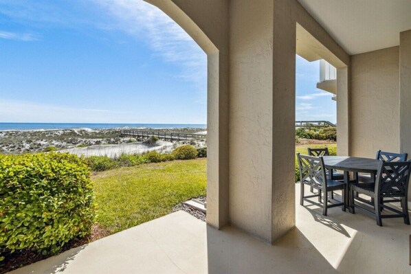 Une terrasse couverte avec vue sur la plage et un pont.