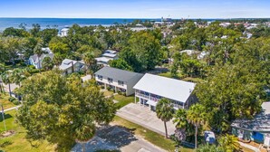 An aerial view of a residential area with houses, a large building with a covered porch, and a view of the ocean. - Short  Walk to beautiful St Joe Bay and Historic downtown Port St Joe.  (Port St. Joe)