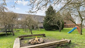 A backyard with a fire pit, a swing set, and a slide. - 7 bedroom awesome home in Rønde (Rønde)