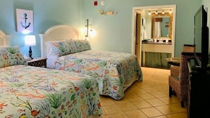 Une chambre d’hôtel avec deux lits, une salle de bain et un téléviseur.