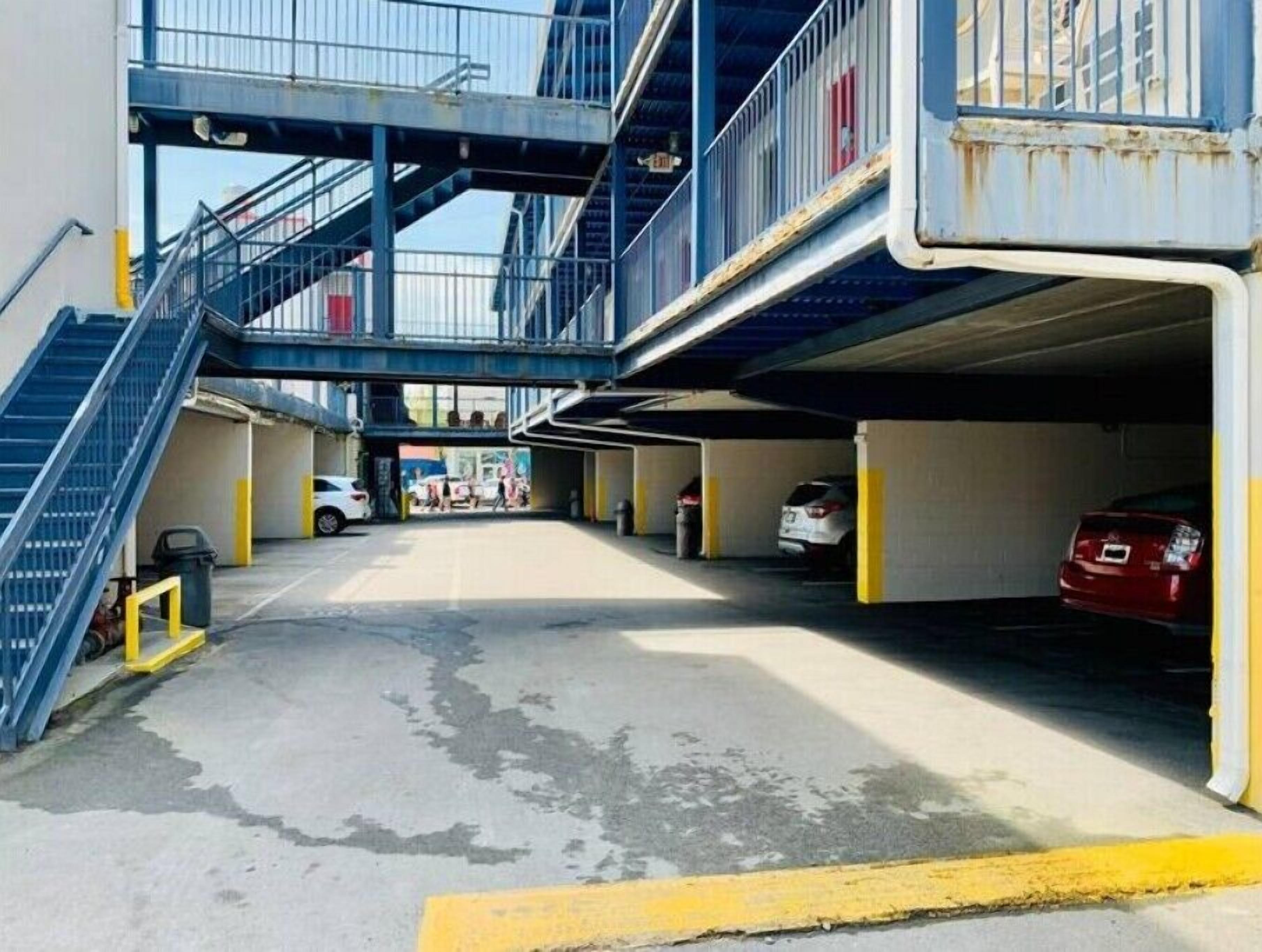 A multi-level parking garage with a stairway leading to an upper level.