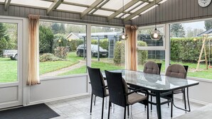 A conservatory with a glass table and chairs, large windows, and a view of the garden. - Awesome home in Nordborg with kitchen (Nordborg)