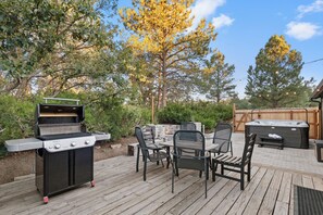 Une terrasse extérieure équipée d’un barbecue, d’un coin salon et d’un jacuzzi.