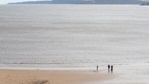 A beach with a calm sea and distant cliffs. - Waimea Apartment 1| Best Location, Beach Front, Parking, Scarborough (North Yorkshire)