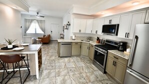 A modern kitchen with white cabinets, a built-in oven, a microwave, and a dishwasher. - Luxury 2BD 2BTH - Condo #5 (Cocoa Beach)