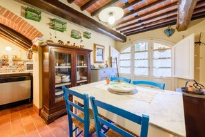 Une cuisine avec une table à manger, des chaises, un buffet et une fenêtre.