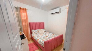 Een slaapkamer met een bed, een kledingkast, een radiator en een deur.