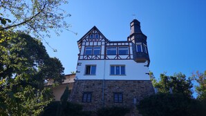 Un edificio grande de varios pisos con una torre destacada y una combinación de estructura de piedra y madera.