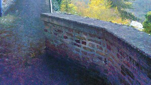 Una escalera de piedra que conduce a un edificio, con vistas a árboles y un bosque al fondo.