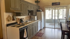 A kitchen with wooden cabinets, a stove, and a refrigerator. - Cozy family fish camp on the Little Red River, a premier trout fishing stream! (Pangburn)