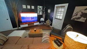 A living room with a television, sofa, and a lamp.