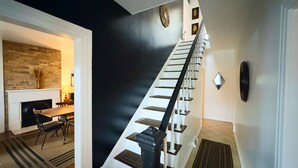 A modern interior with a staircase, a fireplace, and a dining area.