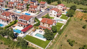 A residential area with multiple houses, each featuring a swimming pool and a well-maintained lawn. - Gorgeous home in Cabrunici (Cabrunici)