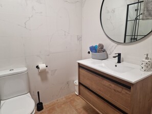 Ein Badezimmer mit Toilette, Waschbecken und Spiegel.