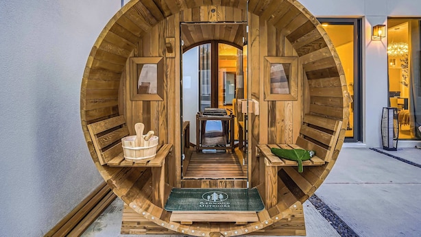 A wooden barrel-shaped entrance with a bench and a welcome mat.