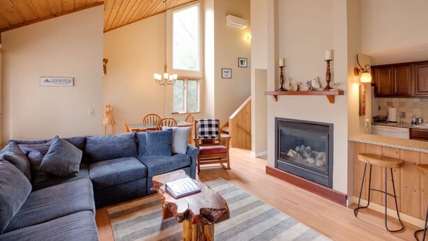 Ein gemütliches Wohnzimmer mit einem blauen Sofa, einem Holztisch und einem Kamin.