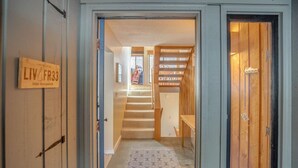 Ein Flur mit einer Holztreppe, einem gemusterten Teppich und einem Schild an der Wand.