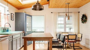 A kitchen with a wooden table, chairs, and pendant lights. - Family Friendly, Peaceful Yard, Dedicated Work Space, Close to Local Attractions (New Cumberland)