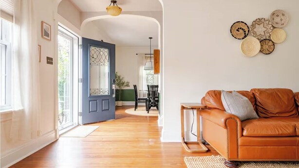 A living room with a brown leather sofa, a wooden coffee table, and a woven rug. - Family Friendly, Peaceful Yard, Dedicated Work Space, Close to Local Attractions (New Cumberland)
