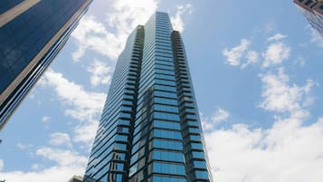 A tall, modern skyscraper with a glass facade, surrounded by other buildings.