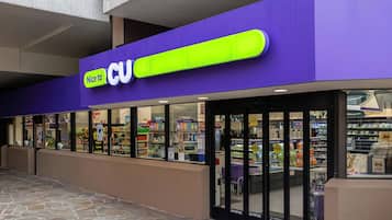 A CU store with a purple exterior and a large illuminated sign.