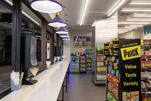 A grocery store aisle with a variety of products and promotional signs. - Bishop Suites Downtown Honolulu (Honolulu)
