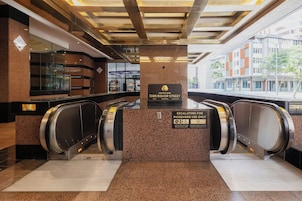 An indoor area with two escalators, a sign for the Executive Centre, and a view of the outside.