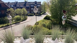 A residential street with houses, a road, and decorative bird sculptures on poles.