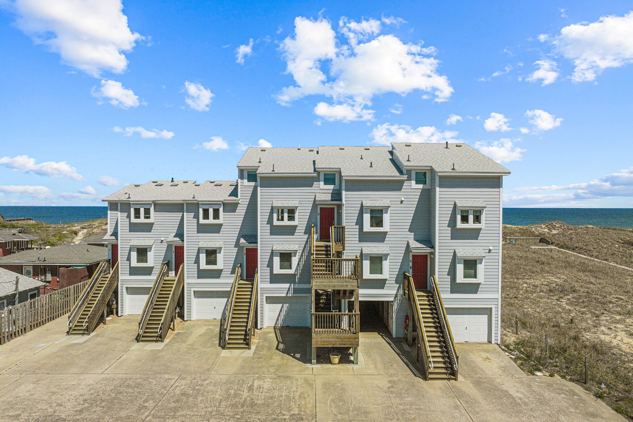 Un edificio de varios pisos con una escalera central y vista al mar.
